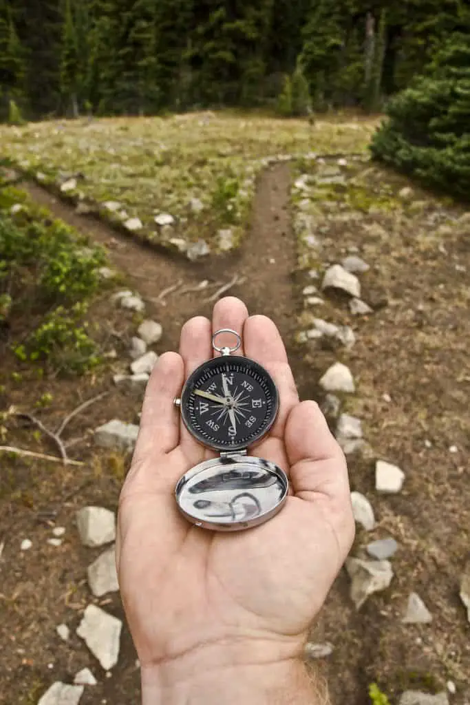 hand holding compass at trail head